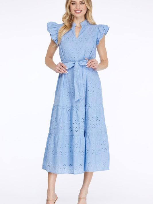 A woman wearing a baby blue eyelet midi dress with a removable belt and ruffle sleeves.
