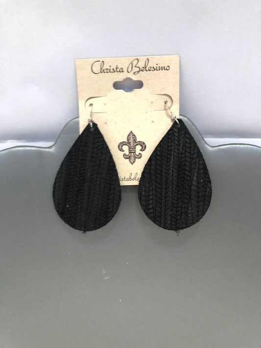 A pair of black textured vegan leather earrings displayed on a card with the brand name 'Christa Bellesima'.