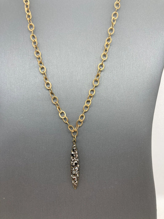 A gold-colored chunky brass chain markasite pendant necklace displayed on a mannequin.