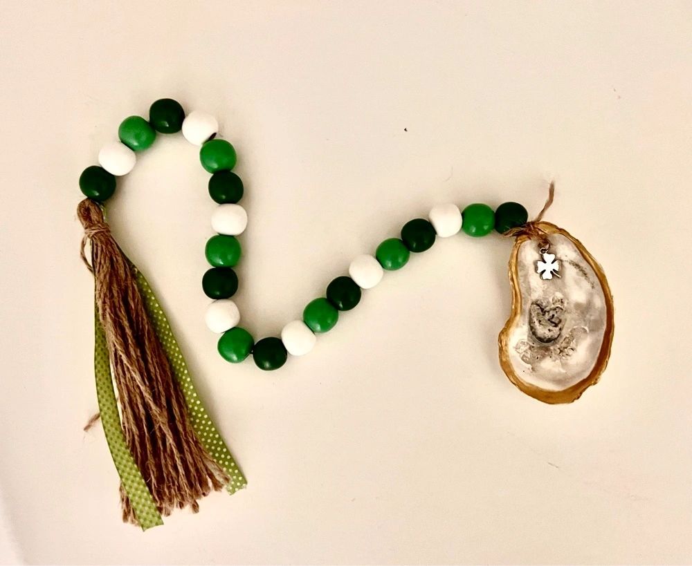 Green and white oyster shell bead garland with shamrock charm for St. Patrick’s Day decor