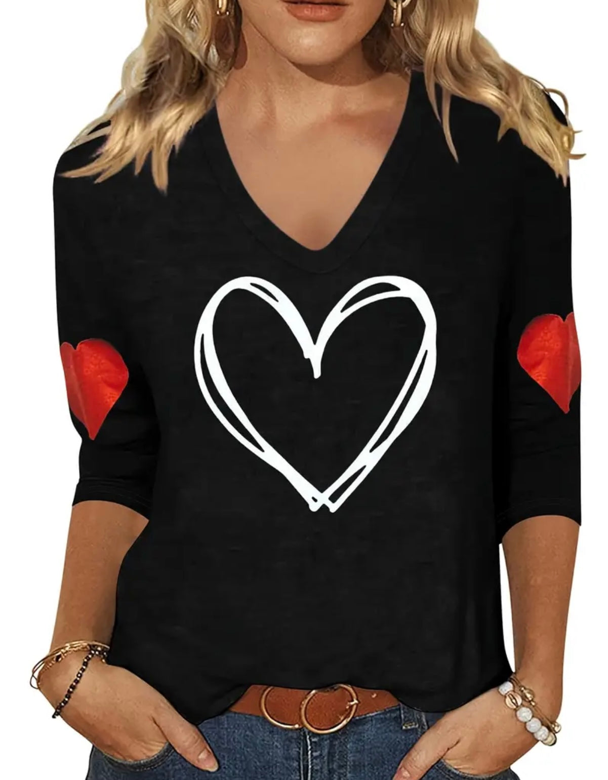 Black long-sleeve shirt with a white heart design and red heart shapes on the sleeves, worn by a person.