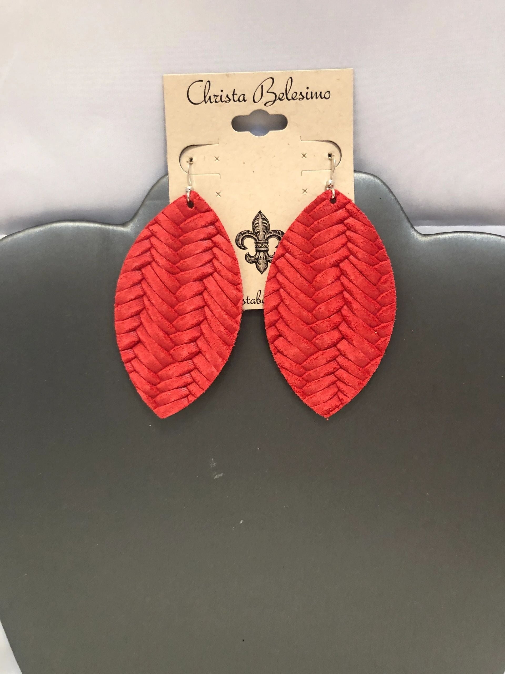 Red weave leaf-shaped vegan leather earrings displayed on a cardboard hanger with the brand name 'Christina Bonomini'.