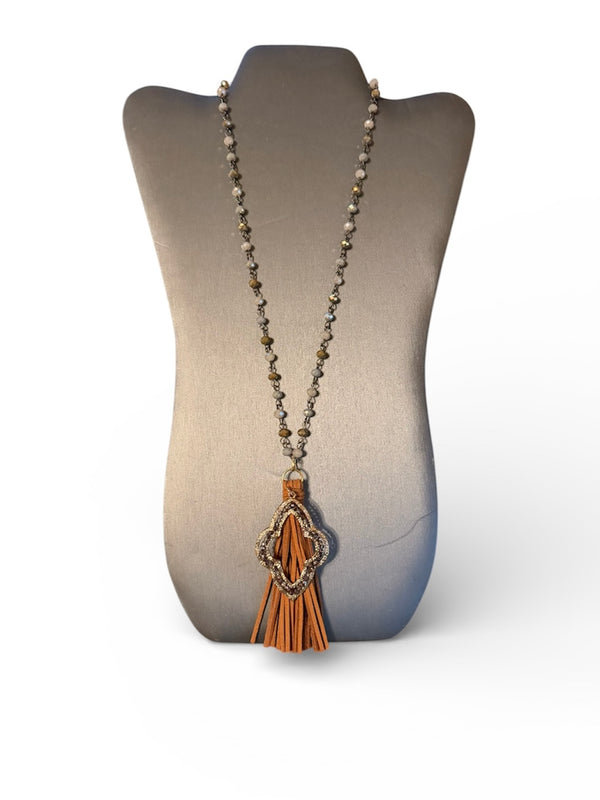 Necklace with a tassel pendant on a gray mannequin bust against a white background