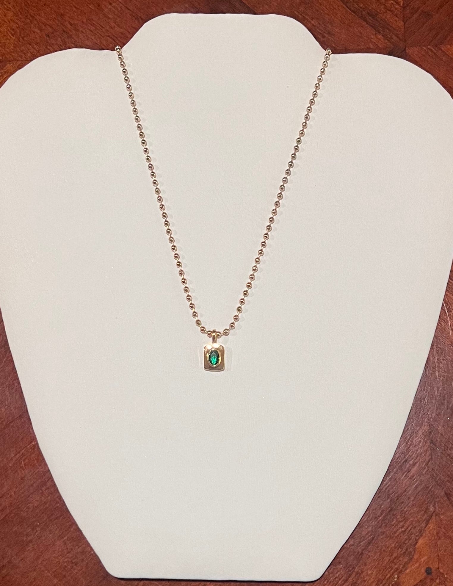 Emerald green rectangular pendant necklace with gold chain
