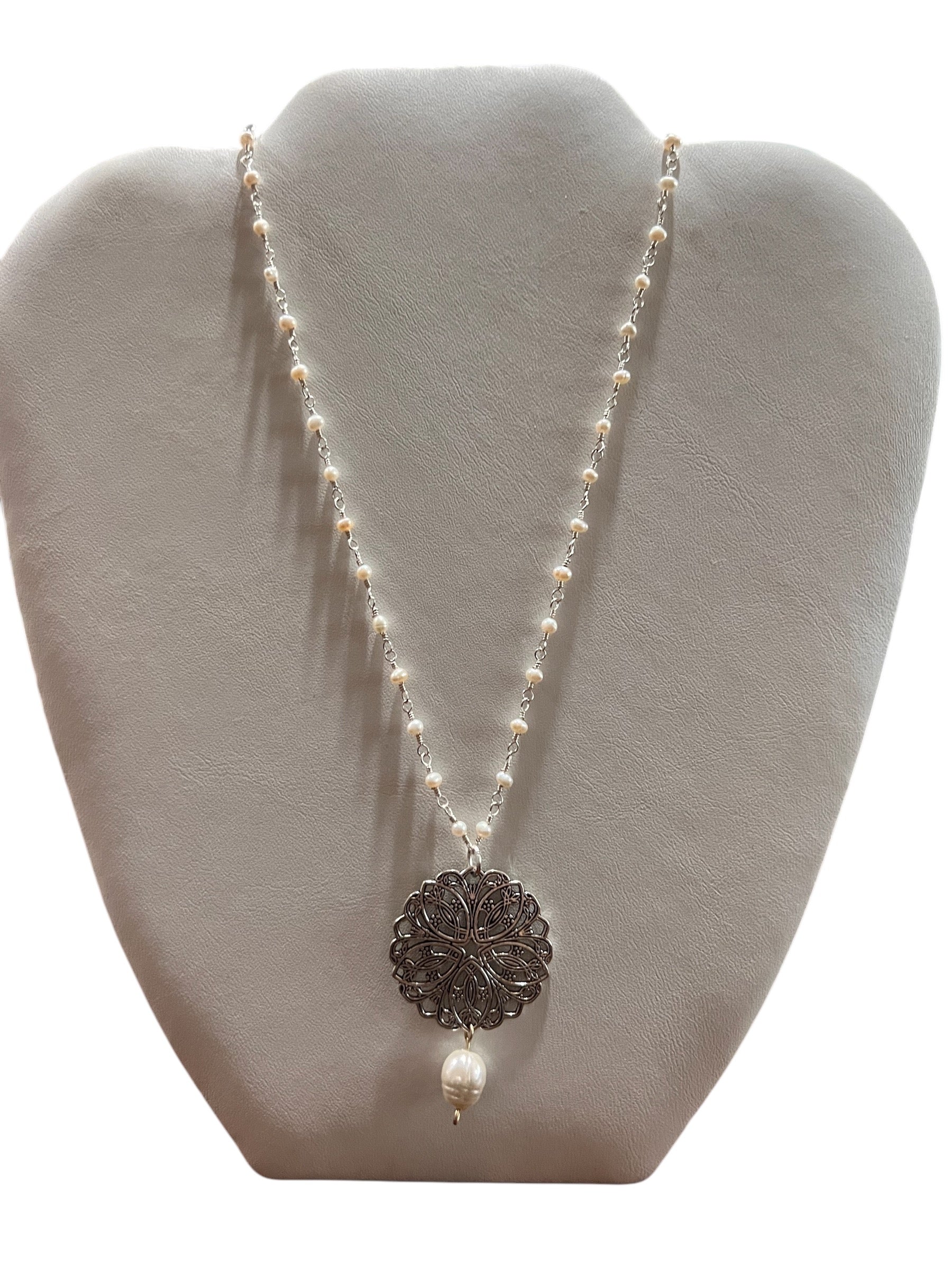 A freshwater pearl and silver disc necklace with a silver disc pendant, displayed on a mannequin bust.