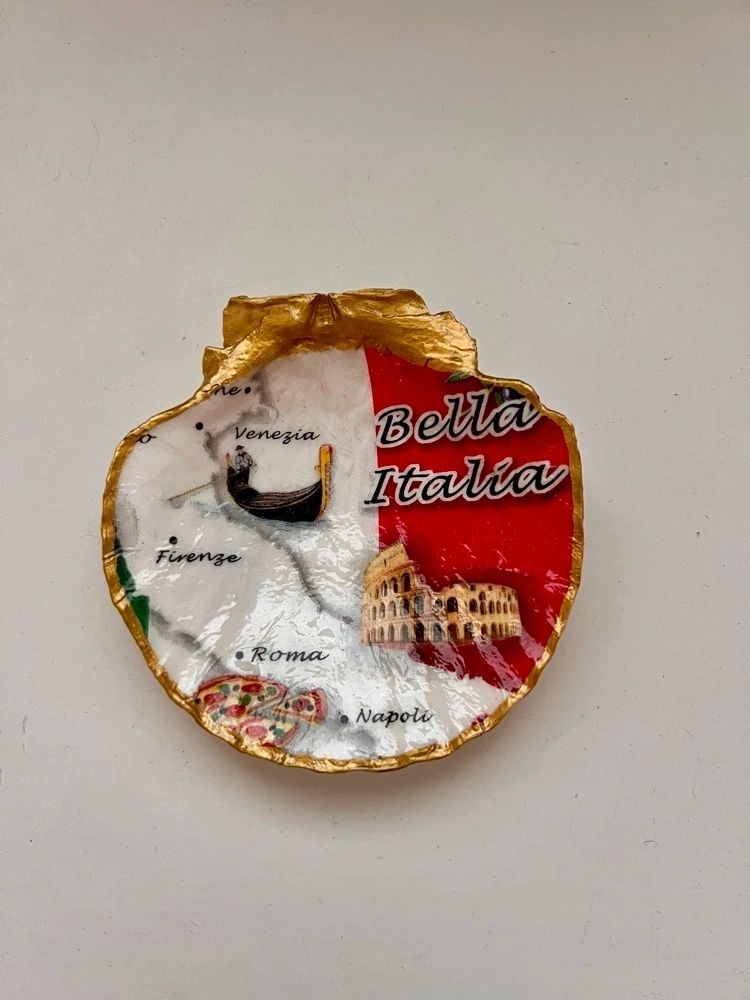 A decorative scallop shell trinket holder with an Italian map and landmarks on it, predominantly red and green with a gold border.