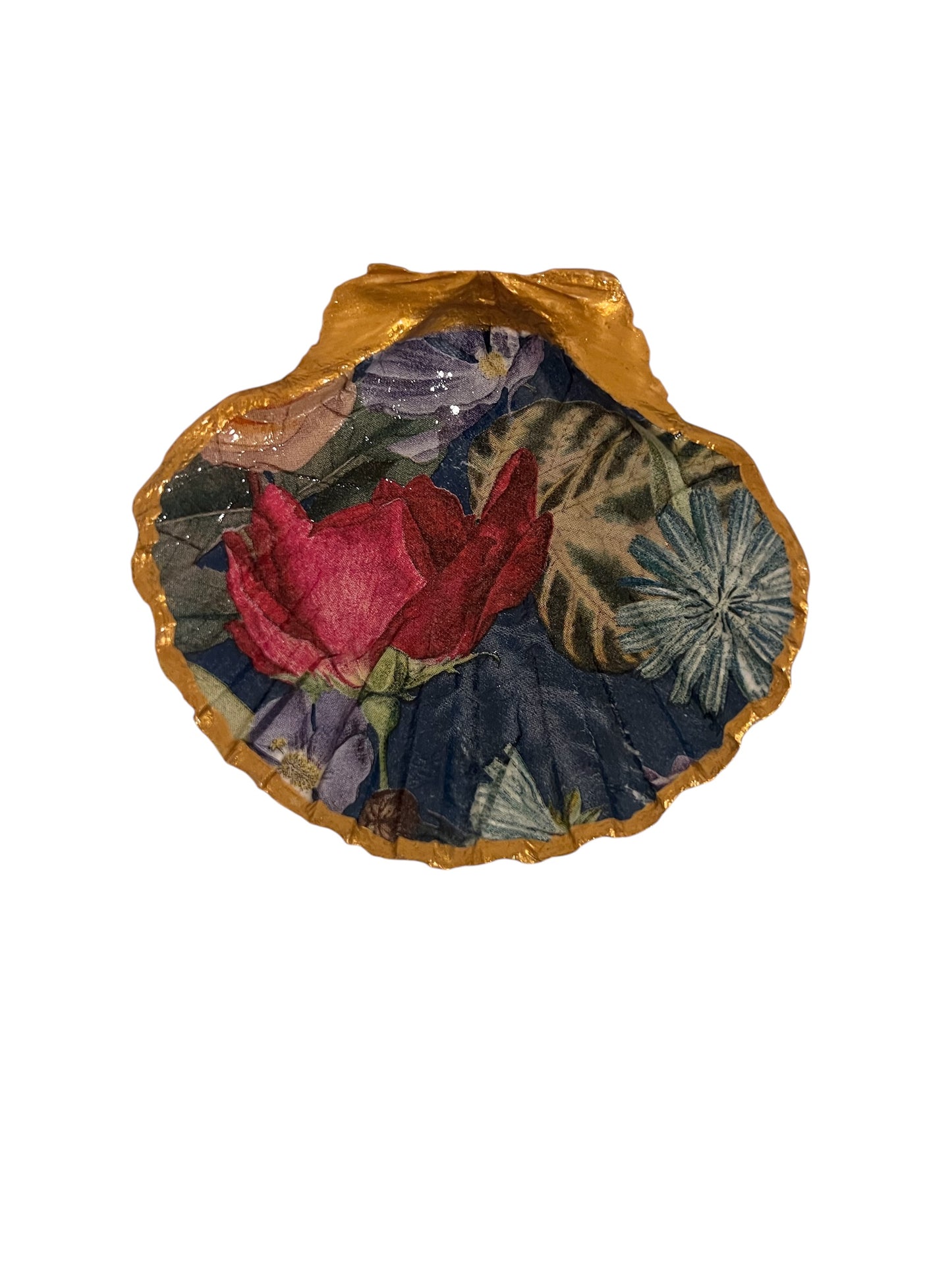 A decorative scallop shell with a rose design on a blue background with gold trim.